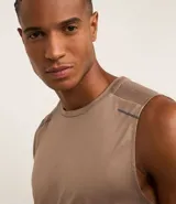 Musculosa deportiva masculina color beige, con cuello redondo y estampado sutil de líneas. Presenta recortes en los hombros y está confeccionada con tecnología Dry para mayor transpirabilidad.