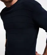 Suéter negro de punto con cuello redondo y mangas largas. Diseño con líneas horizontales en relieve.