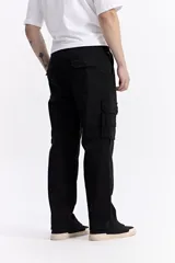 Pantalón cargo de corte baggy, color beige, con bolsillos laterales tipo cargo con cierre y solapa, y diseño de pierna ancha.