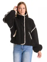 Campera negra de símil corderito, marca Elan. Tiene cuello alto, cierre frontal con solapa y botones, bolsillos inclinados en la parte delantera y ruedo y puños elastizados. Forro interno a tono.