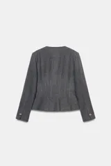 Blazer de corte entallado con cuello redondo, manga larga y hombreras. Presenta cierre frontal con botones dorados y una textura sutil en la tela.