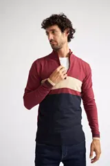 Sweater de tejido de punto con diseño color block en tonos bordó, beige y azul marino. Presenta cuello alto con cierre frontal parcial, mangas largas con puños acanalados y logo bordado en el pecho.