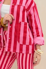 Campera de denim con diseño de rayas verticales en tonos rojo y rosado, cuello clásico, cierre frontal con botones metálicos y bolsillos appliqued en el frente.