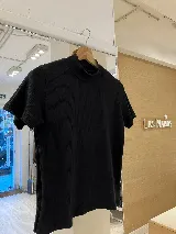 Polera blanca de morley con cuello alto y mangas cortas.