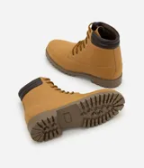 Bota estilo worker de caña media con acabado tipo nobuck. Presenta puntera redondeada, cuello acolchado en contraste, cierre con cordones y ojalillos metálicos. Cuenta con suela dentada de goma para mayor tracción.