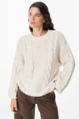 Sweater de abrigo en tejido de punto con hilado grueso, de silueta holgada y hombro caído. Presenta un diseño de ochos en el frente y en las mangas.