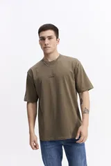 Remera de manga corta color verde militar, con escote redondo y fit regular. Presenta un pequeño estampado de texto en el pecho.