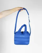 Bandolera azul acolchada con correa ajustable y asa de mano.