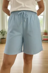 Short tipo bermuda de tiro alto en color celeste, con cintura elástica y cordón ajustable. Presenta un corte suelto y cómodo, ideal para un estilo casual.