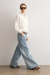 Camisa blanca de manga larga con cuello camisero y apliques florales bordados tono sobre tono.