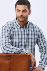 Camisa de manga larga a cuadros en tonos azul y blanco, con cuello con botones y un bolsillo en el pecho con detalle bordado.