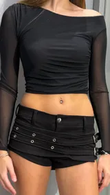 Short de tiro bajo confeccionado en material engomado, con diseño de doble cintura decorativa, ojales metálicos y hebillas laterales ajustables.