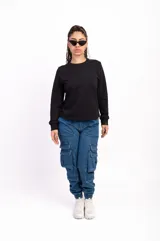 Buzo negro de algodón de corte clásico con cuello redondo y mangas largas. Tiene un pequeño logo bordado en el pecho.