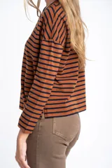 Remera de manga larga, corte al cuerpo, con cuello redondo. Presenta un patrón de rayas horizontales en color marrón óxido y azul marino.