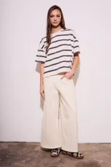 Remera de algodón color crudo con rayas horizontales negras, corte holgado y mangas cortas.