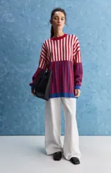 Sweater de tejido jacquard con diseño de rayas verticales en tonos rojo, blanco y azul. Presenta cuello redondo, hombros caídos y puños en contraste de color azul.