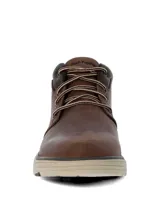 Botín Hush Puppies modelo William, confeccionado en cuero marrón con cordones bicolor. Presenta un diseño de caña media con cuello acolchado y suela de EVA en tono beige con base dentada.
