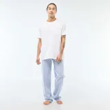 Pijama de dos piezas compuesto por una remera blanca de manga corta con bolsillo frontal y un pantalón largo de color azul claro, confeccionado en tela de popelina.