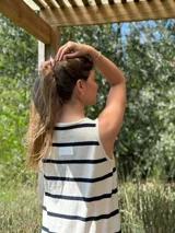 Vestido largo tejido a rayas horizontales azul marino y blancas, sin mangas, con cuello redondo y tajos laterales.