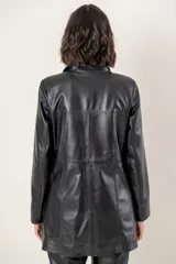 Campera de cuero en tono azul con efecto gastado, de corte recto y largo medio. Presenta cuello camisero, cierre frontal con botones a presión ocultos bajo una solapa y bolsillos laterales con cierre metálico.