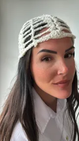 Gorro de crochet color crudo, con diseño calado y lentejuelas.