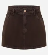 Short pollera de sarga color beige, con diseño de tiro medio, trabillas en la cintura, bolsillos laterales y cierre frontal con botón y cremallera.
