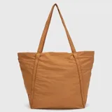 Bolso tipo tote de diseño amplio y ligero, confeccionado en tela técnica de acabado mate. Presenta doble asa superior para llevar al hombro, bolsillo frontal abierto y logo de la marca sutilmente grabado en la parte superior.