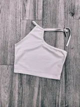 Top blanco irregular con un solo bretel y espalda descubierta.