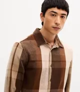 Camisa de hombre marca Marfinno, confeccionada en franela con estampado de cuadros en tonos marrones y beige. Presenta cuello inglés, cierre frontal con botones y mangas largas con puños abotonados.