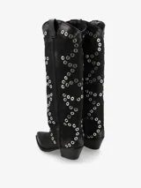 Bota de caña alta negra de cuero, con punta fina, taco bajo y aplicación de ojalillos metálicos a lo largo de la caña.
