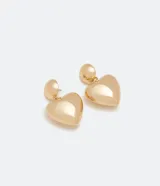 Caravanas medianas de metal color dorado con diseño bold, compuestas por una base redonda y un colgante en forma de corazón.
