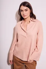 Camisa color salmón de corte oversize, confeccionada en lino y viscosa, con cuello clásico, cierre frontal con botones y mangas largas con puños anchos.
