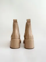 Botas tipo chelsea de cuero color visón, con plataforma, taco cuadrado y punta cuadrada.