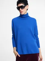 Sweater de cuello alto color azul eléctrico, de punto acanalado, con mangas ajustadas y cuerpo amplio y suelto.