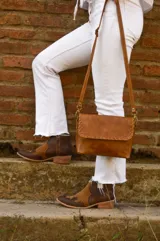 Bandolera de cuero color camel con correa larga regulable.