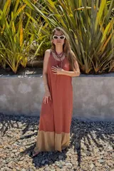 Vestido largo color ladrillo, de breteles finos y corte holgado. Presenta un panel inferior color beige.