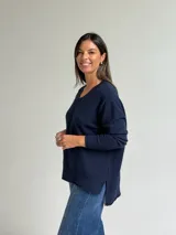 Sweater de punto en color azul marino, con escote en V, manga larga con puños acanalados y costura central vertical en el frente.