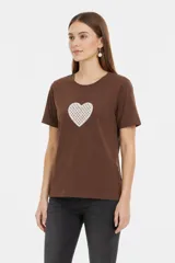 Remera blanca de manga corta y cuello redondo, confeccionada en algodón, con un diseño holgado y estampado frontal de estrella roja con textura y detalles de estrellas pequeñas.