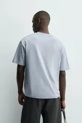 Camiseta de corte relajado confeccionada en algodón con textura irregular, cuello redondo y manga corta.