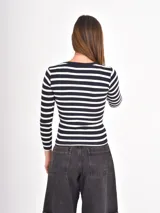 Remera de manga larga con diseño de rayas horizontales finas en blanco y negro, cuello redondo y corte ajustado.