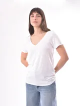 Remera blanca de manga corta con escote en V, de tejido ligero y ligeramente traslúcido.