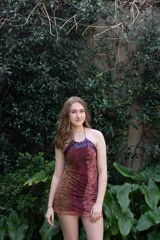 Vestido corto azul con escote halter y espalda descubierta. Presenta detalles de encaje negro en el escote y los laterales.