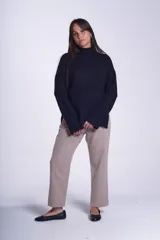 Sweater color crema de media polera, corte holgado y mangas largas. Tejido de punto con detalles acanalados en cuello, puños y ruedo.