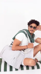 Bolso deportivo gris de nylon con doble asa y correa regulable. Cuenta con dos bolsillos exteriores con cierre, un bolsillo exterior de rejilla y un bolsillo interior con cierre.