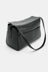 Bolso de hombro de piel color negro, con diseño estructurado, solapa superior y correa ajustable para el hombro.