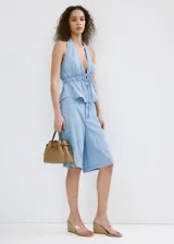 Top de denim suave color celeste con cuello halter, escote en V profundo y cordón ajustable en la cintura.