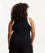 Musculosa negra de ribana con cuello redondo y sisas con ribete blanco en contraste.