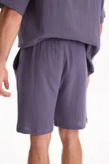 Bermuda negra de muselina con corte baggy, estilo deportivo y cordón ajustable en la cintura.