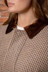 Campera de lana con estampado de cuadros pequeños en tonos marrones y beige. Presenta un cuello de pana en color marrón oscuro, cierre frontal con cremallera oculta por una solapa con botones y mangas largas con puños abotonados.