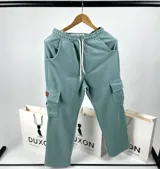 Pantalón de jogging verde con cintura elástica ajustable con cordón, bolsillos laterales y bolsillos cargo con etiqueta de cuero en los muslos.